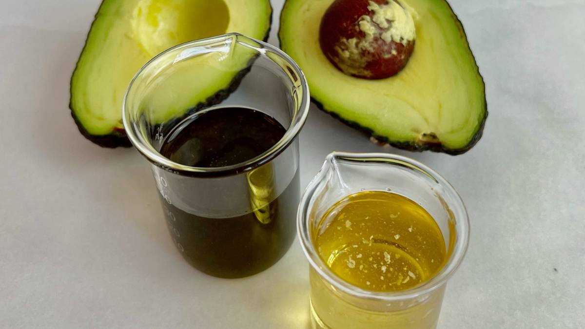 Avocado Oil one dark and one light avocado oil with sliced avocado fruit